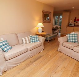 A living room with seating and kitchen area at High Sea View