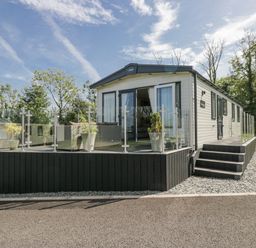 A mobile home with a deck and planters at Grasmoor View Lodge