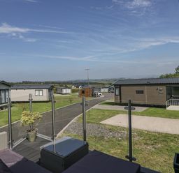 An outdoor area with holiday homes and a pathway at Grasmoor View Lodge in
