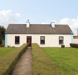 A house with a pathway and hedges at The Farmhouse in Tralee, County Kerry