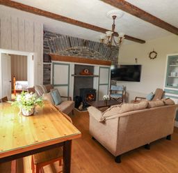 A living room with a sofa, coffee table, and fireplace at The Farmhouse in Tralee, County Kerry