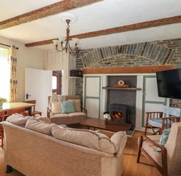 A living room with a fireplace and seating area at The Farmhouse in Tralee, County Kerry