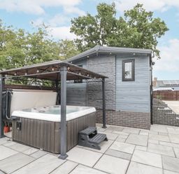 An outdoor area with a hot tub and patio at The Cabin in Thornton Dale