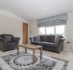A living room with a sofa and armchair in The Cabin Thornton Dale