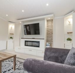 A living room with a television and fireplace cabinet at The Cabin Thornton Dale