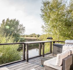 An outdoor area with a sofa and grill at The Larch House in Farndon