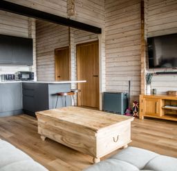 A living room with kitchen cabinets and a coffee table at The Larch House in Farndon