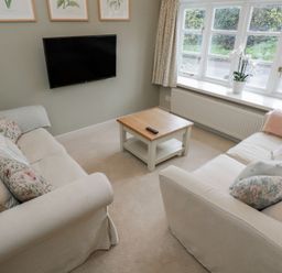 A living room with a sofa and table at Granary Cottage