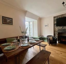 A dining room with a table set for a meal at Llanrwst Apartment