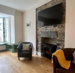 A living room with a sofa and fireplace at Llanrwst Apartment