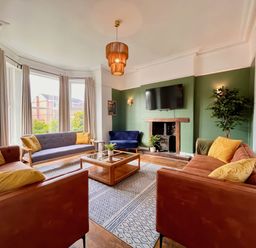 A living room with sofas and a television at Clarence House in Llandudno