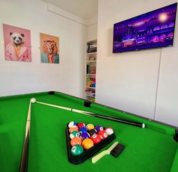 A game room with a pool table and television at Clarence House in Llandudno