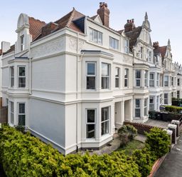 A building with multiple windows and bushes in Llandudno at Clarence House