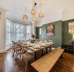 A dining room with a table set for a meal at Clarence House in Llandudno