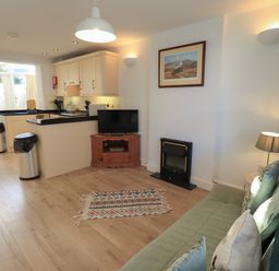 A living room with a sofa and television at Swirl Howe in Keswick