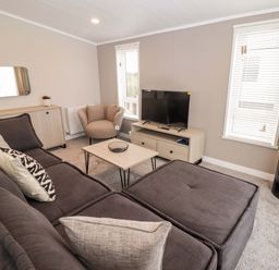 A living room with a sofa, coffee table, and television at Dolphin in Haverfordwest