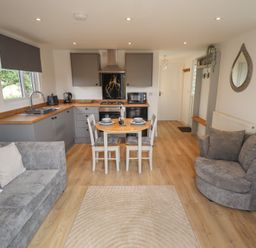 A kitchen with dining table and seating area at Pear Tree Lodge in Alford