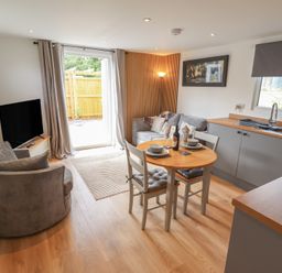A living room with a sofa and a dining table at Pear Tree Lodge in Alford