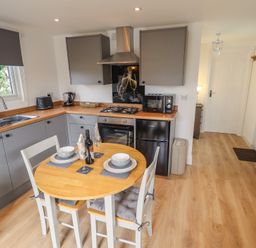 A kitchen with a table and chairs at Pear Tree Lodge in Alford