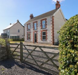 A house with a gate and hedge at Hawthorns in Swansea