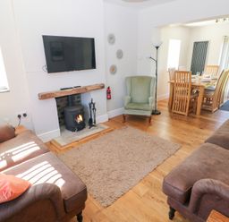 A living room with a television and fireplace at Hawthorns in Swansea