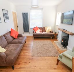A living room with a sofa and armchair at Hawthorns in Swansea