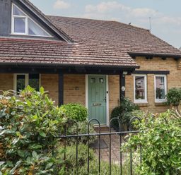 A house with a green door and windows at June Cottage in Wool