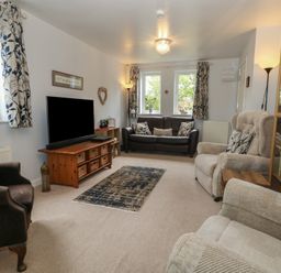 A living room with sofas and a television at June Cottage in Wool