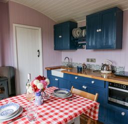 A kitchen with a table and chairs at Brondel Luxury Shepherd's Hut