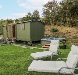 A garden with a shepherd's hut and hot tub at Brondel Luxury Shepherd's Hut in