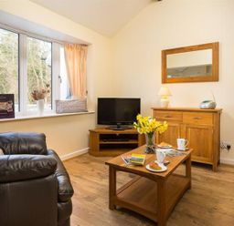 A living room with a sofa and coffee table at 2 Riverside Cottages Ambleside