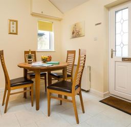 A dining room with a table and chairs at 2 Riverside Cottages Ambleside