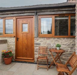 An outdoor area with wooden furniture and a flower pot at The Old Cart Shed in Gorsley