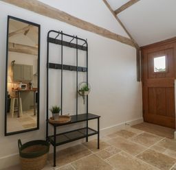 An entrance with a coat rack and mirror at The Old Cart Shed in Gorsley