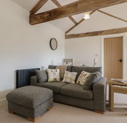 A living room with a sofa and side table at The Old Cart Shed in Gorsley