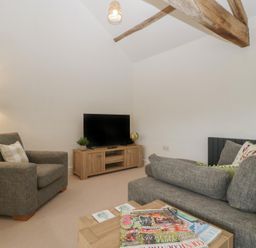 A living room with a television and seating area at The Old Cart Shed in Gorsley
