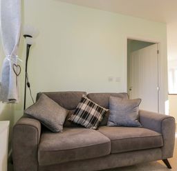 A living room with a sofa and cushions at Swallows Nest in Bourton-On-The-Water