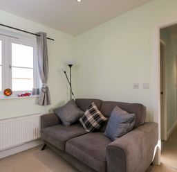 A living room with a sofa and window at Swallows Nest in Bourton-On-The-Water