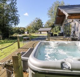 A hot tub on decking in an outdoor area at Cadno in Llanybydder