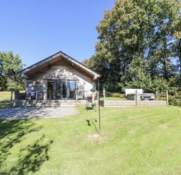 A house with a deck and surrounding grass at Cadno in Llanybydder