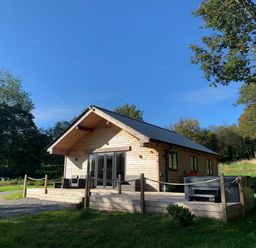 A cabin with a deck and hot tub at Cadno Aber near Llanybydder