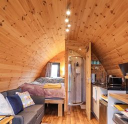 A studio with a bed, sofa, shower, and kitchen counter at The Pod at Greenbank Isle of Skye