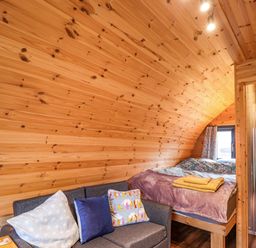 A bedroom with a bed and couch at The Pod at Greenbank Isle of Skye