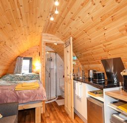 A studio with a bed, kitchenette, and shower at The Pod at Greenbank Kilbride near Broadford