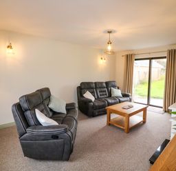 A living room with reclining chairs and a coffee table at Shamrock House