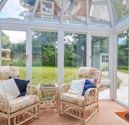 A conservatory with rattan chairs and a table at Upper Court Cottage Broad Langdon near Wainhouse Corner