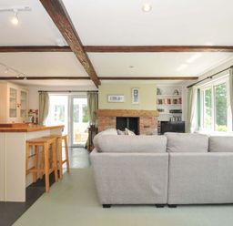 A living room with a fireplace and kitchen island at Upper Court Cottage Broad Langdon near Wainhouse Corner