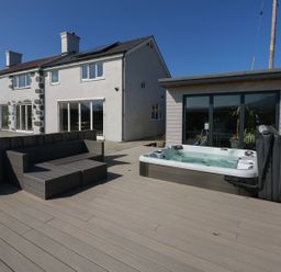An outdoor area with a hot tub and seating at Criw in Bryncroes near Sarn Meyllteyrn