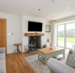 A living room with a fireplace and television at Criw near Sarn Meyllteyrn