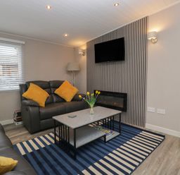 A living room with a sofa and coffee table at Owls Nook Lodge, Langdale 9, White Cross Bay near Windermere